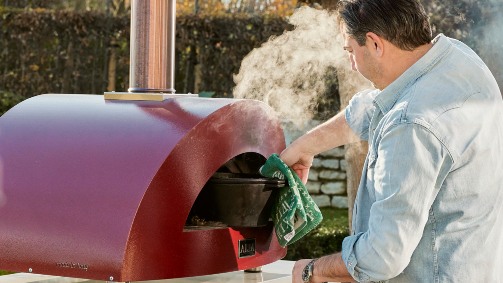Man cooking in a roasting tin on a pizza oven