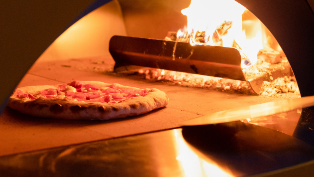 Pizza cooking in a wood-fired pizza oven